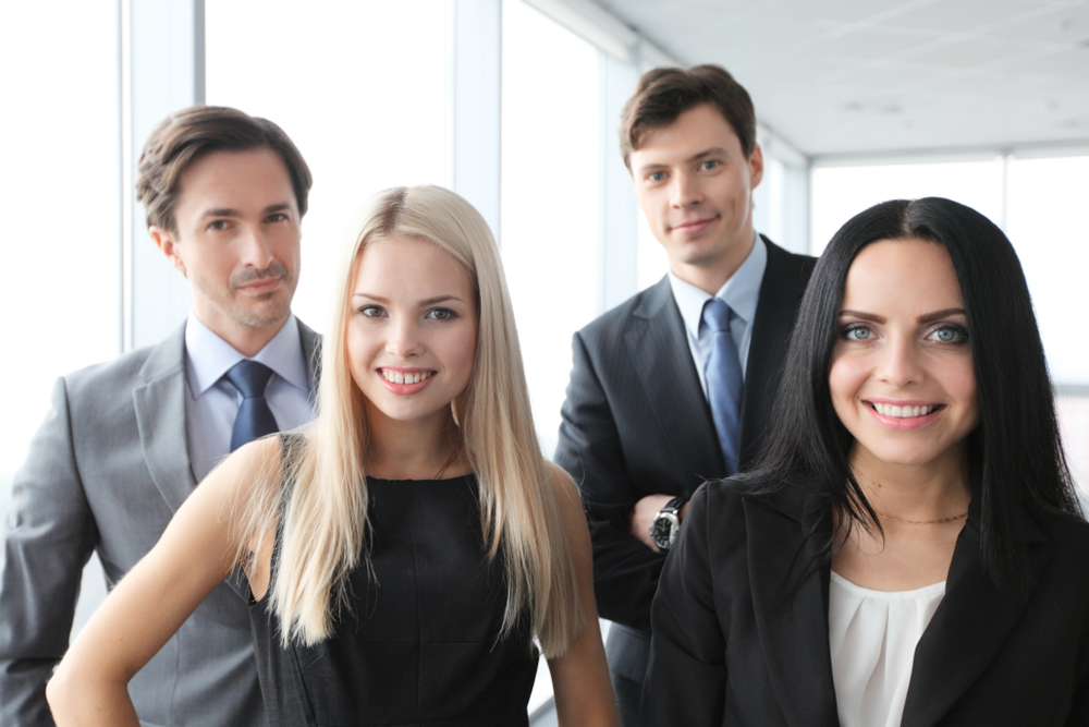 Four business colleagues smiling in a bright office