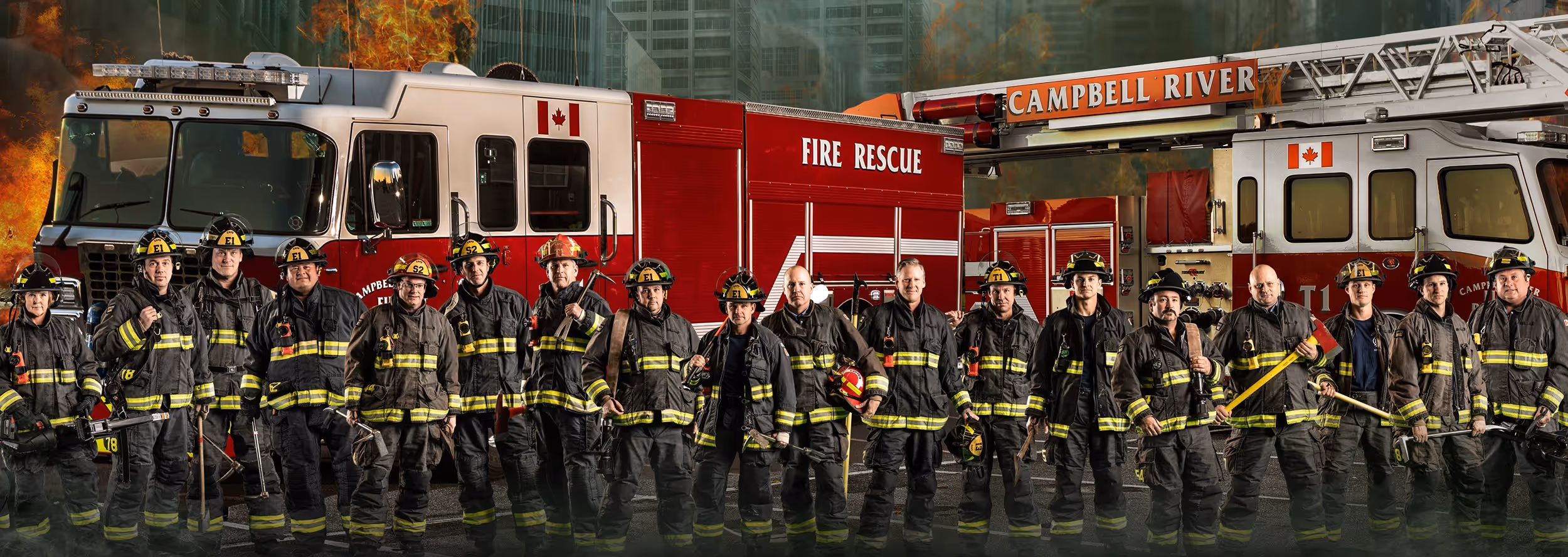 Campbell River firefighters standing in full gear in front of fire rescue trucks for a group lineup photo