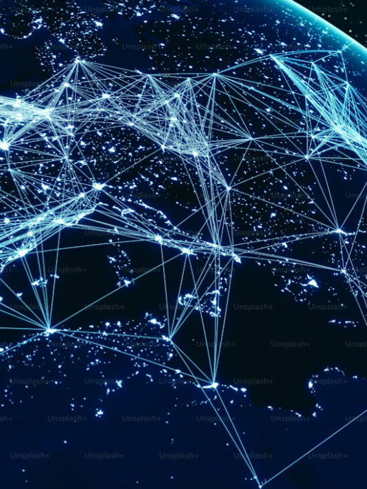 Digital illustration of Earth’s surface at night showing interconnected glowing networks representing a decentralized global network.