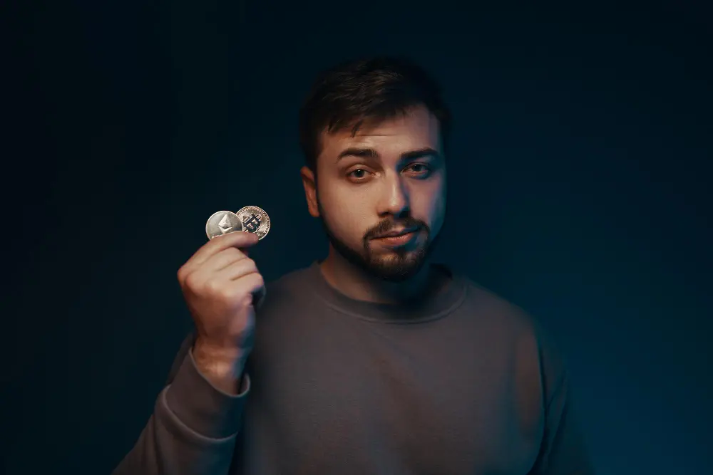 Man in plaid shirt plugging an Ethernet cable into the back of a desktop computer.