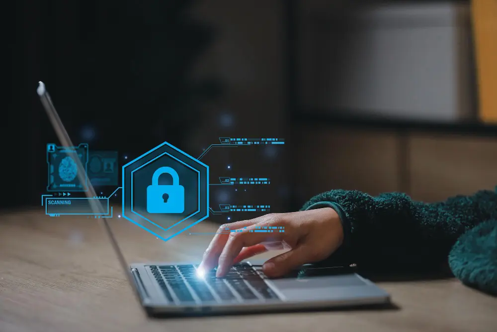 Man in plaid shirt plugging an Ethernet cable into the back of a desktop computer.