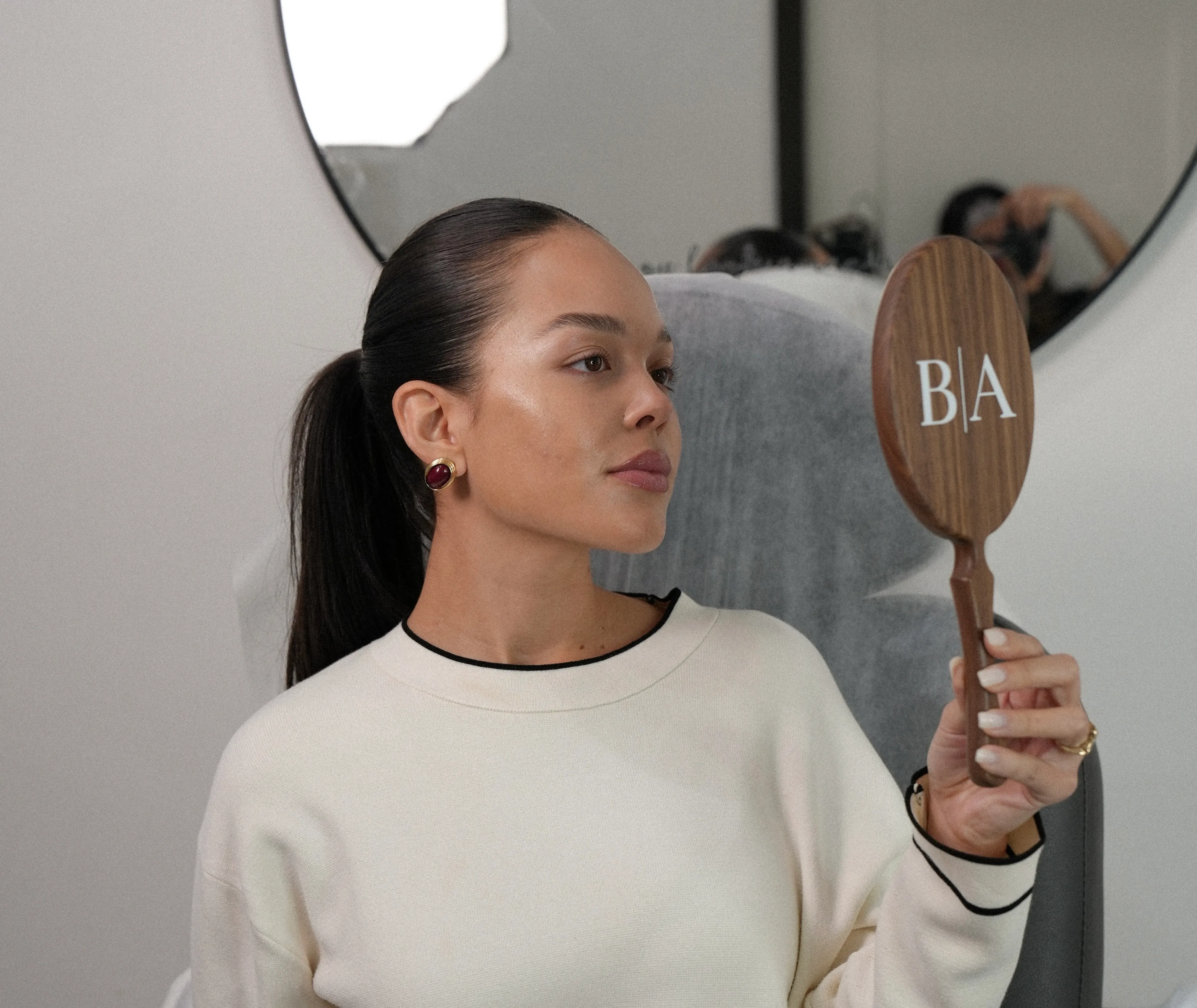 Patient admiring her facial balancing results in a Bonita Aesthetics mirror