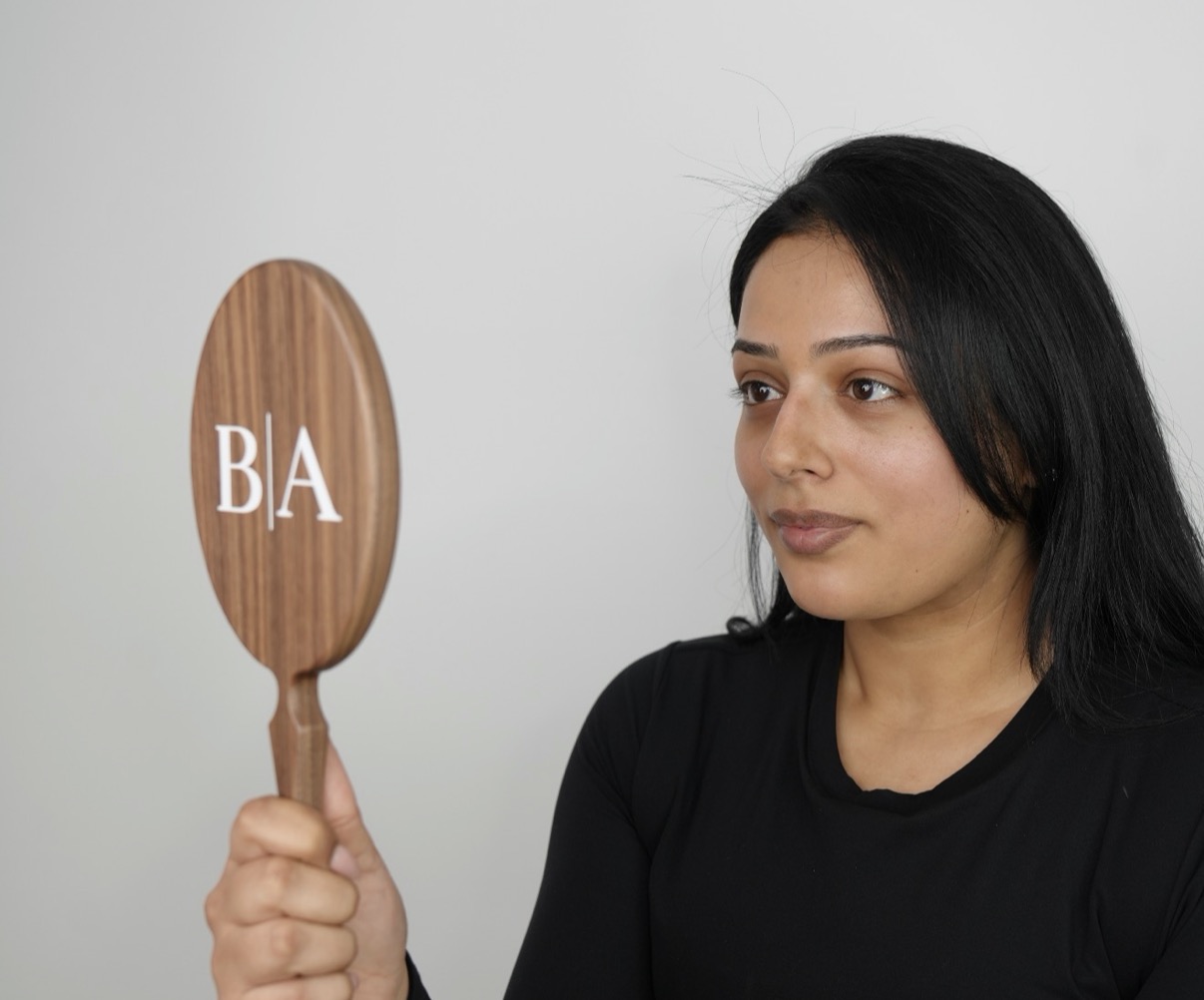 Patient viewing her results in a Bonita Aesthetics before and after mirror