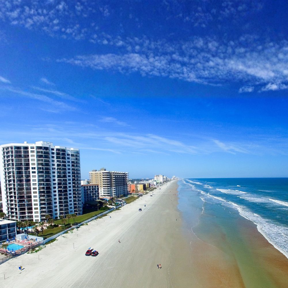 Aerial view of a wide beach with high-rise condos along the Florida coast