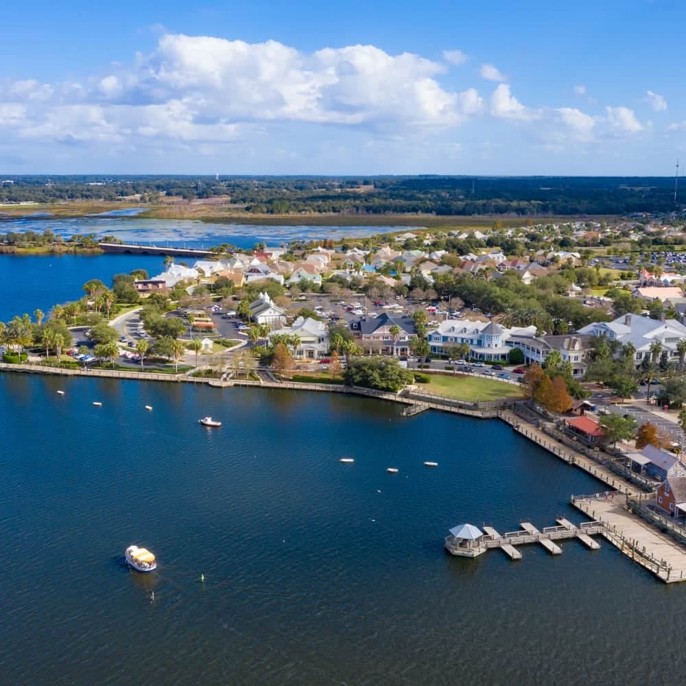 Aerial view of a lakefront town center with docks, boats, and shops