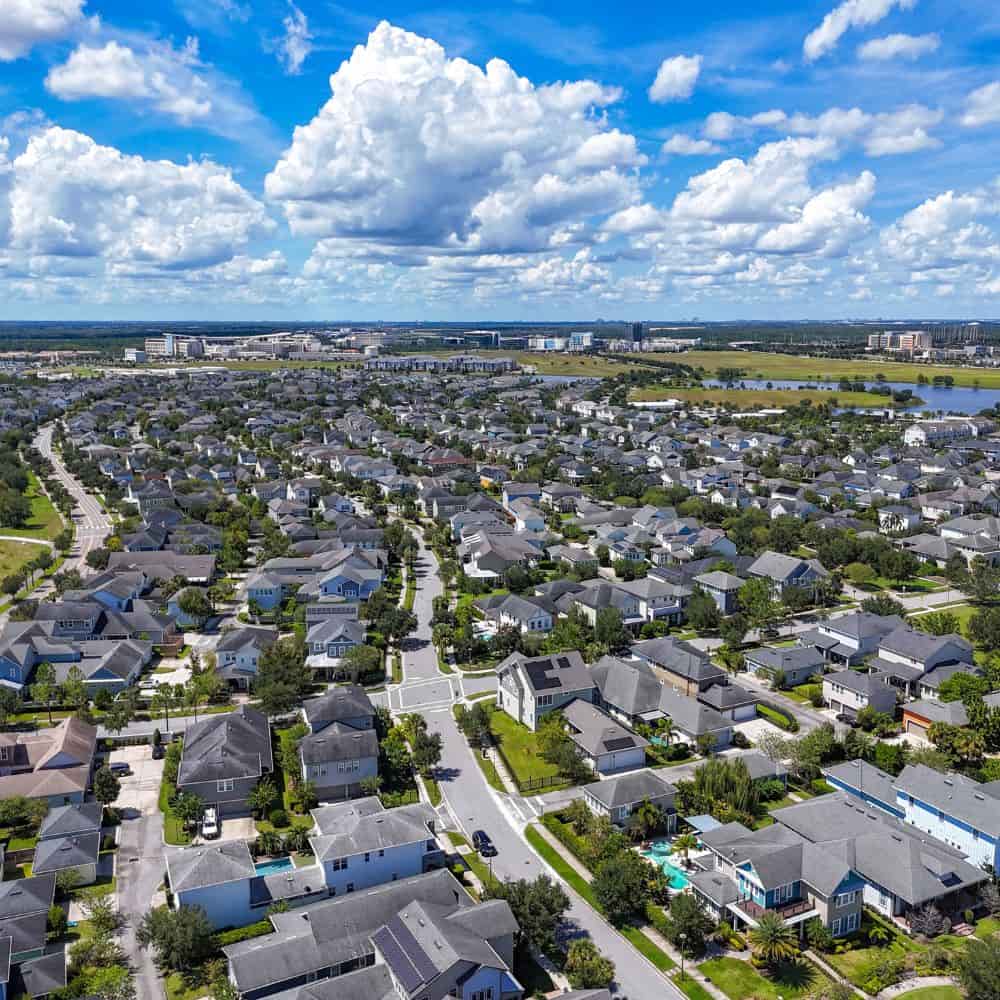 Aerial view of a dense residential neighbourhood under large clouds in Dr. Phillips, Florida