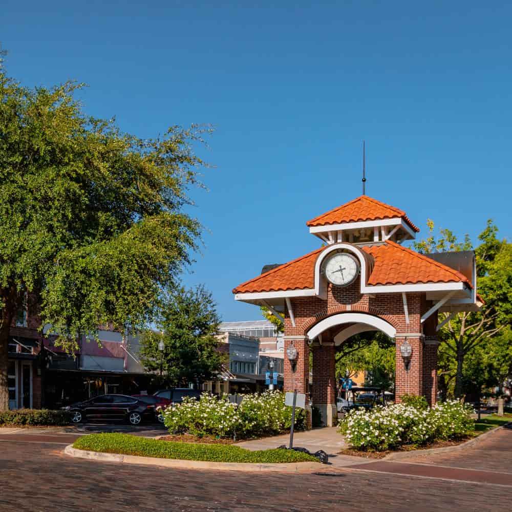 Brick clock pavilion with a terracotta roof on a downtown street in Winter Garden, Florida