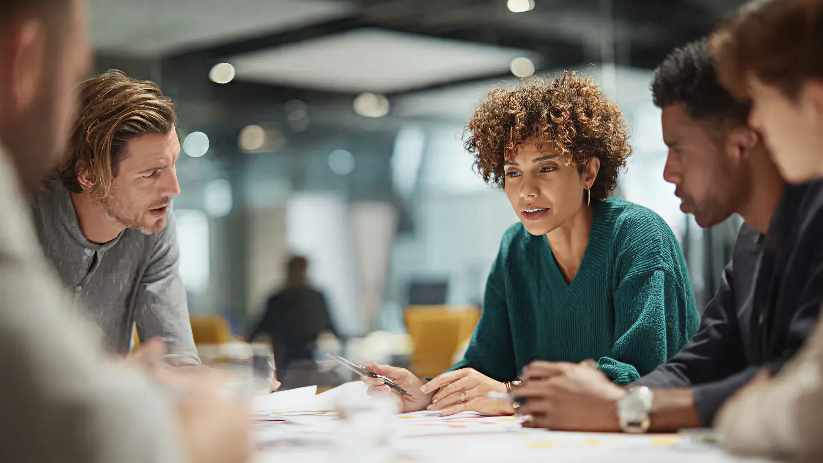 An office filled with green and white cubicles.