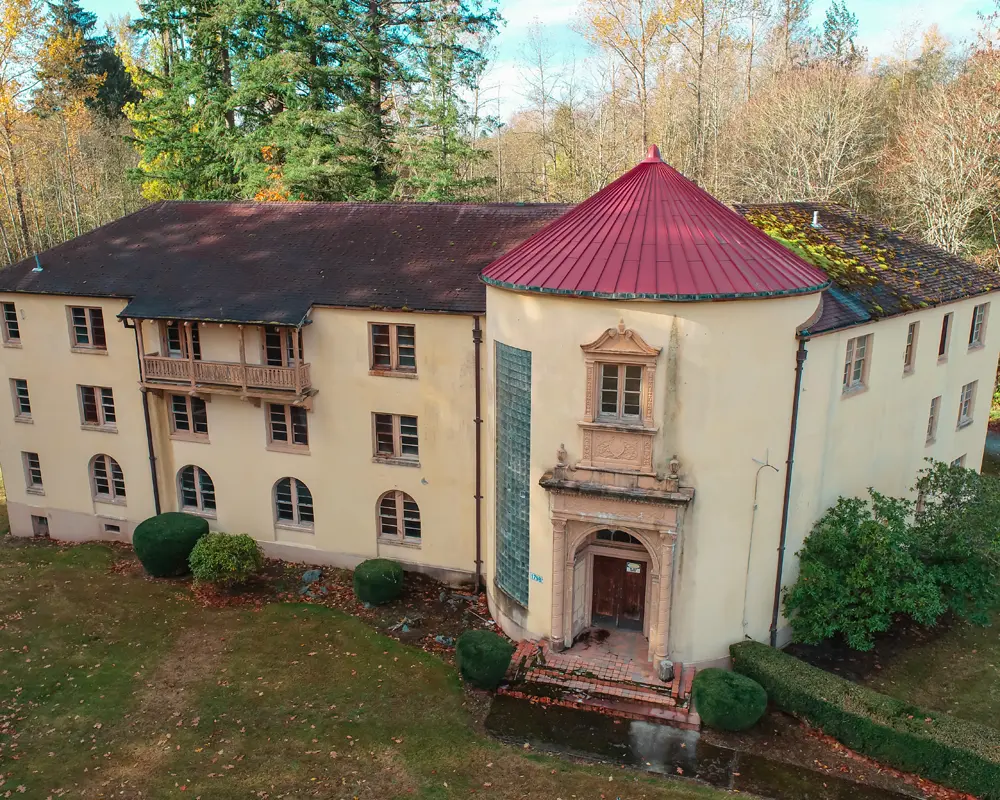 swift center Trevennen building spanish colonial revival with red roof surrounded by trees and shrubs