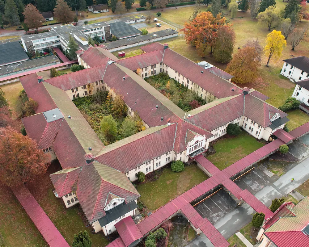 SWIFT center Denny Building with red roof and long hallways connecting different parts of the building surrounded by trees with fall foliage. Aerial view. 
