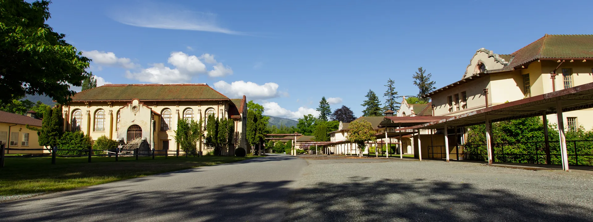 adaptive resuse projects swift center historic spanish colonial revival buildings with trees greenery mountains in the distance and blue skies with some clouds