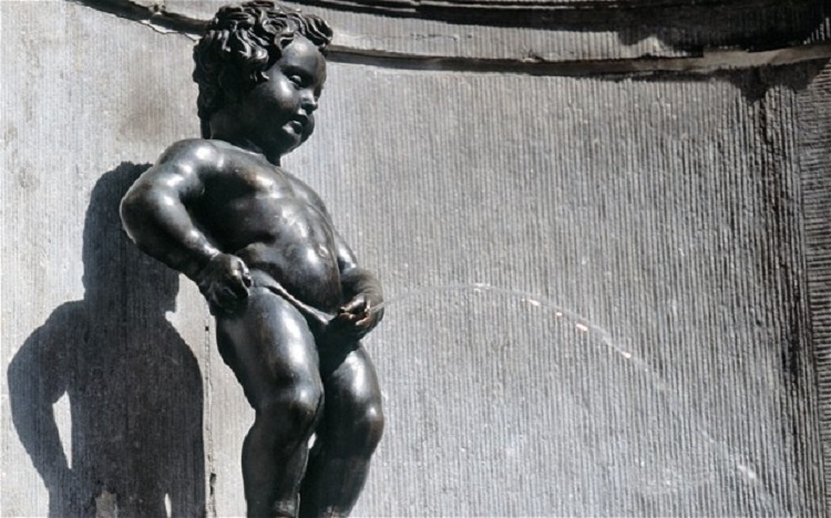 Bronze statue of a small boy urinating, known as Manneken Pis, with water arcing from him in a fountain.