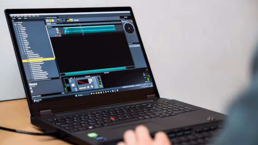 Laptop displaying audio editing software with a person's hand on the keyboard.