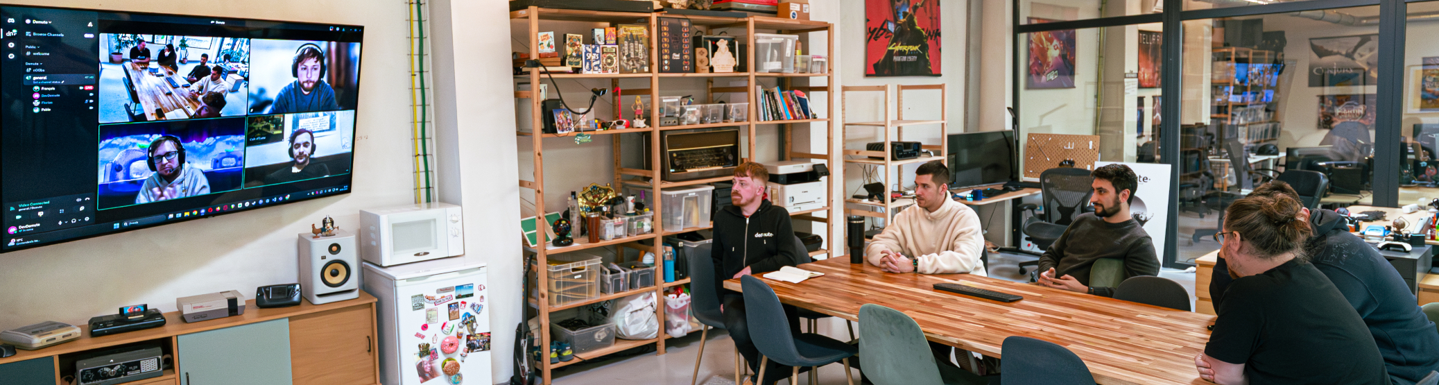 Man looking at a large screen displaying black-and-white photos of people with distorted faces arranged in circles around the word 'demute'.