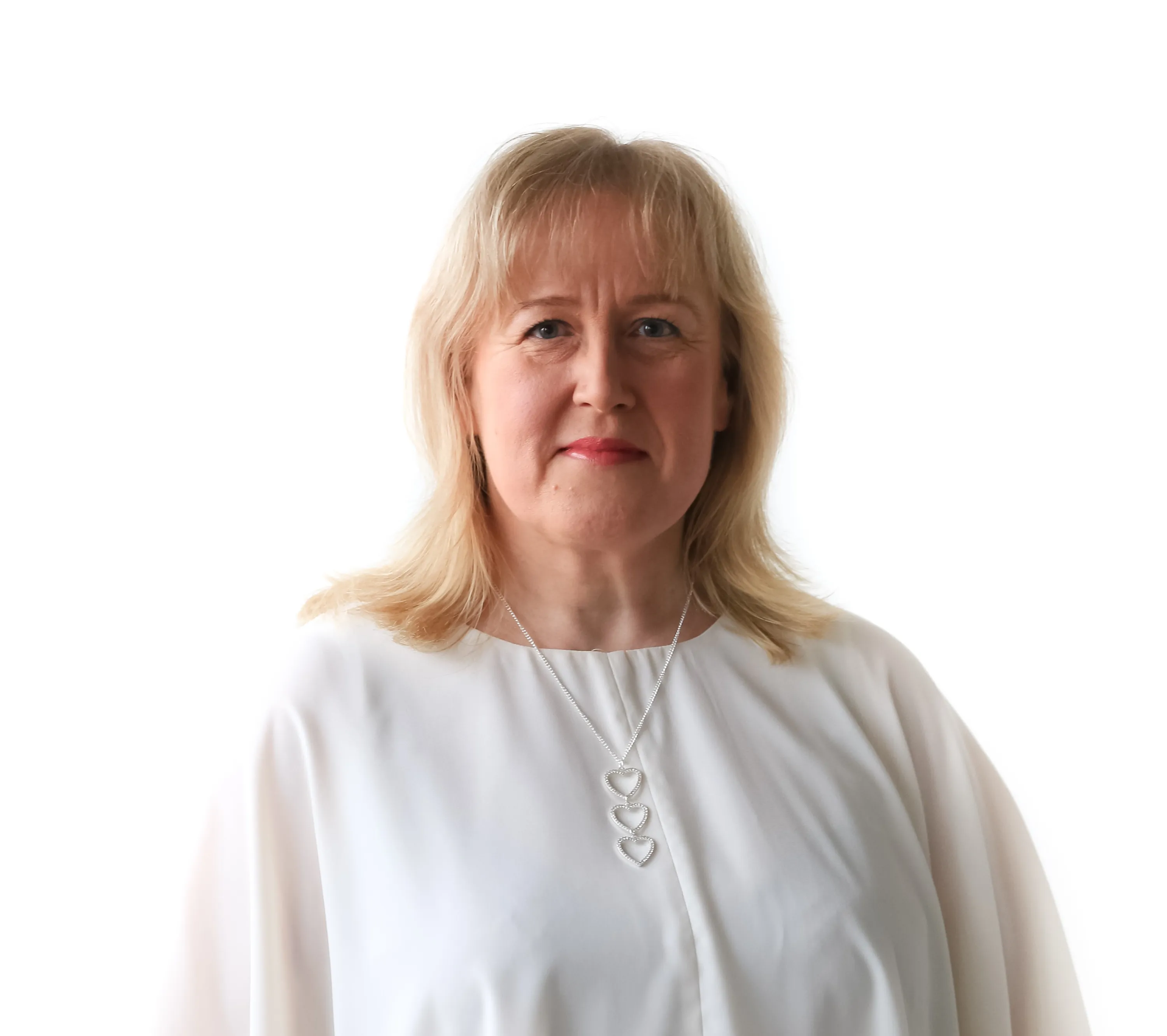 Valkotakkisen naisen muotokuva, jossa on vaaleat hiukset ja sydänkoru, valaistus on kirkas.