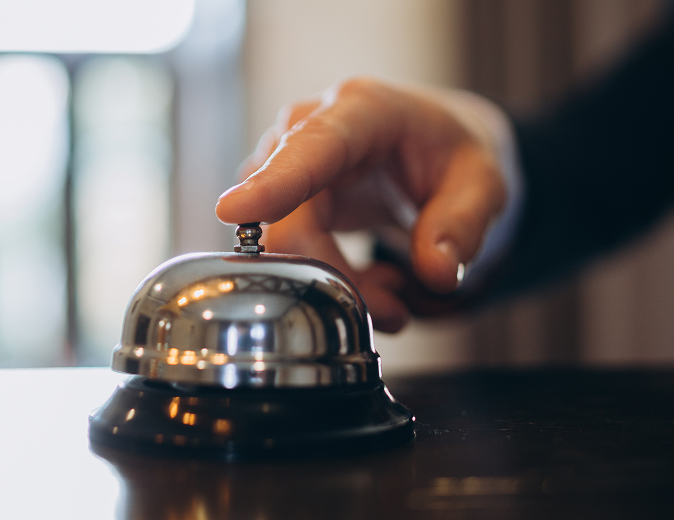 a hand ringing a bell at a front desk