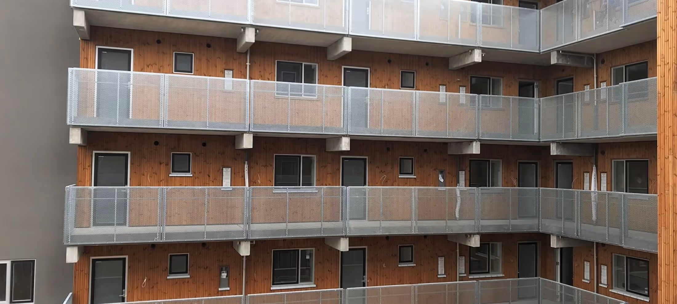 En lejlighedsbygning med altaner og altaner på hver etage.