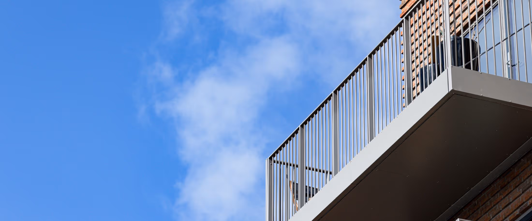 En fugl sidder på balkonen i en bygning.