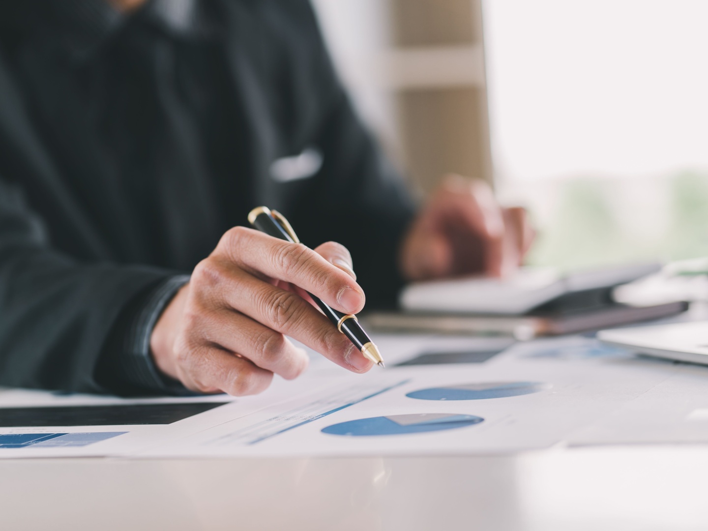 Adult day program manager tracking key performance indicators on a computer at an organized desk.