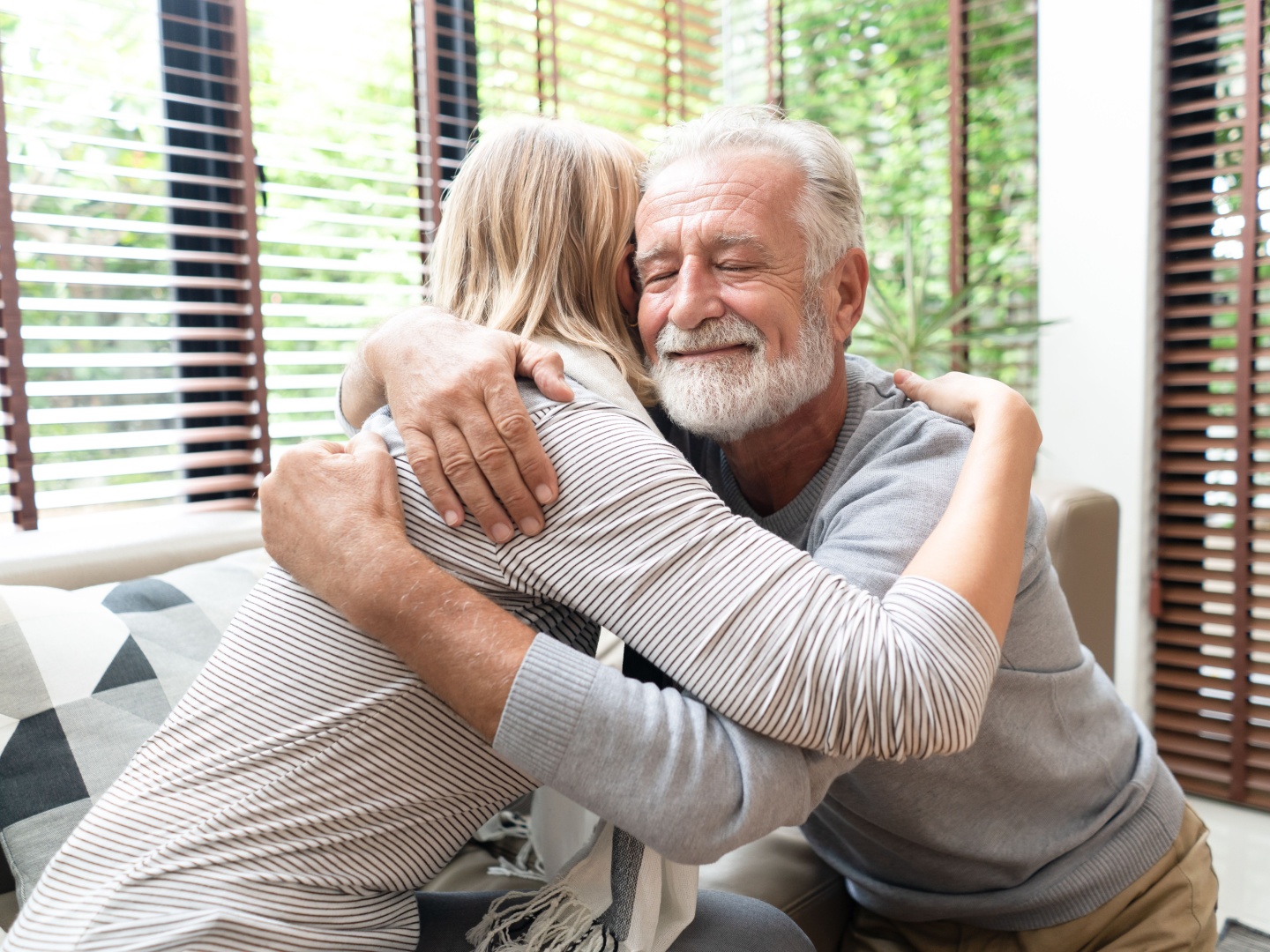 Senior man hugging his adult child, sharing a moment of comfort and family dementia support
