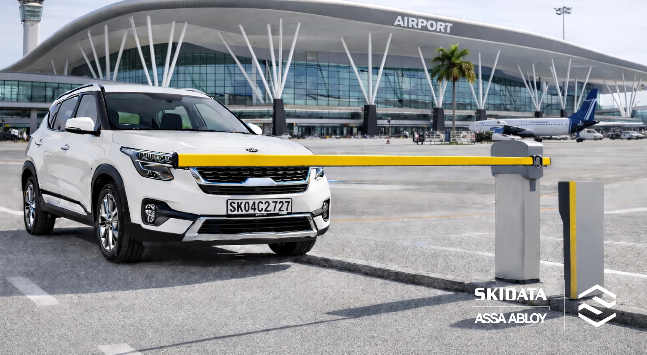 White SUV stopped at a yellow parking barrier in front of a modern airport terminal building.