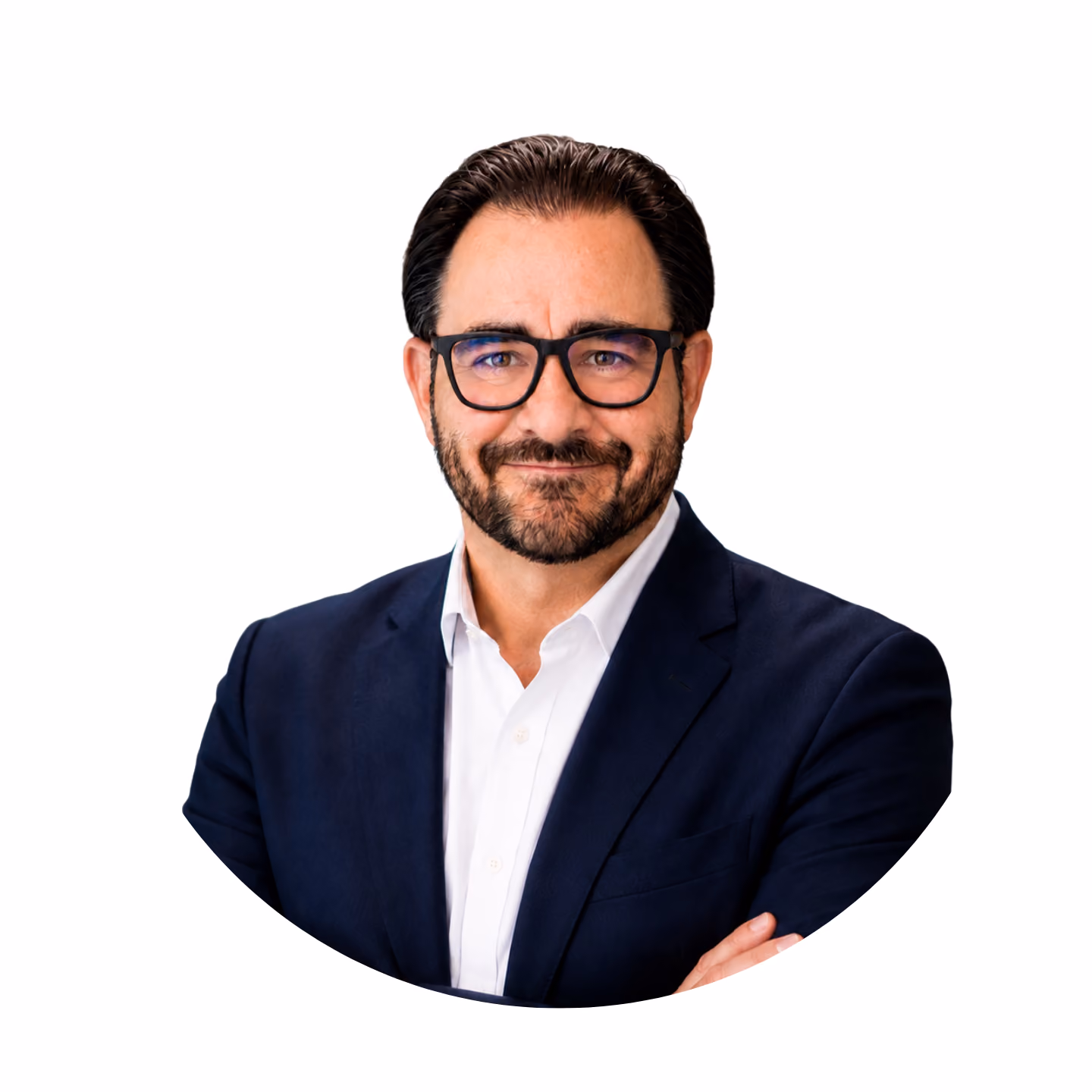 Man with dark hair, beard, and glasses wearing a white shirt and navy blazer, smiling with arms crossed.