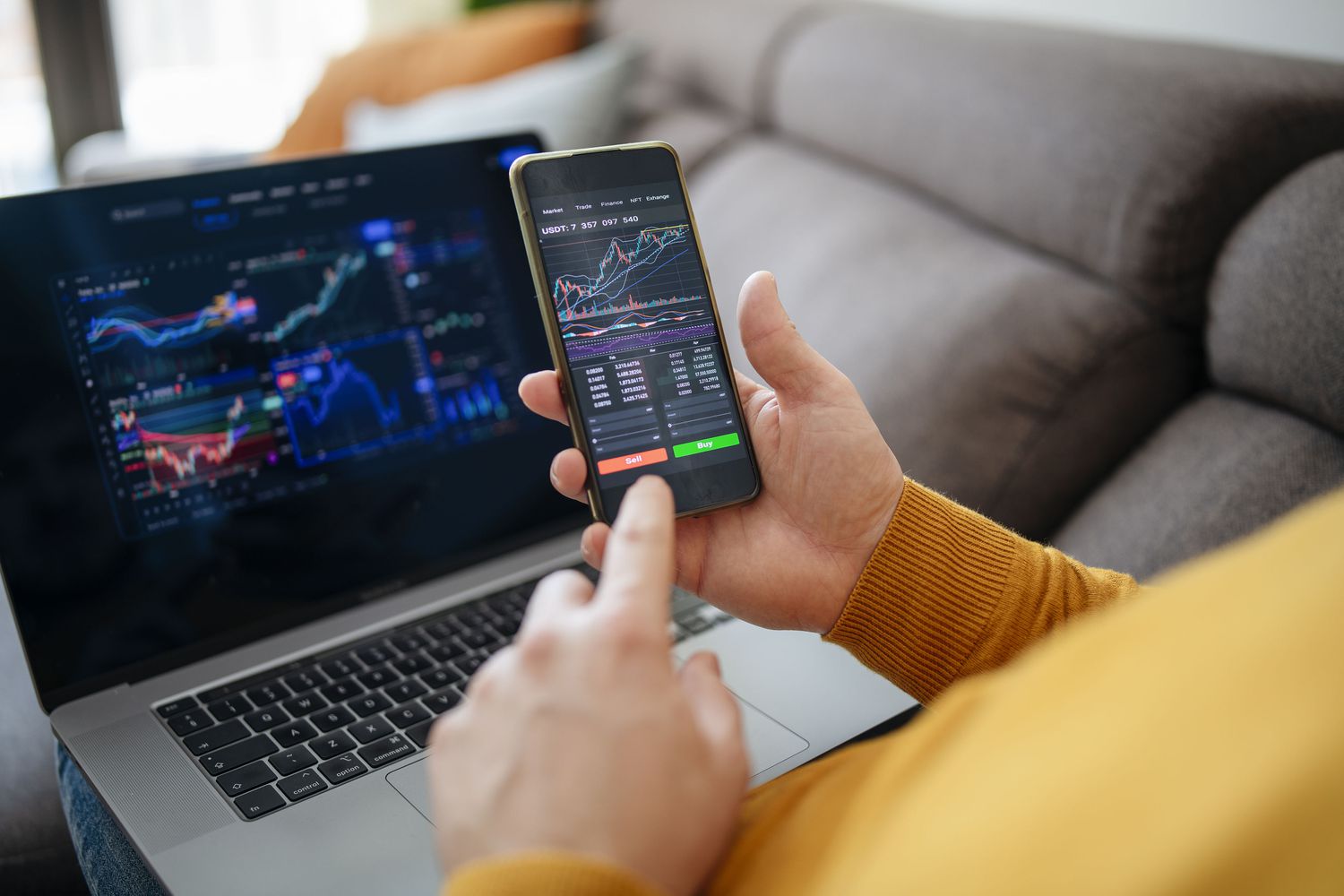 man trading on his phone and laptop - Day Trading Risk Management
