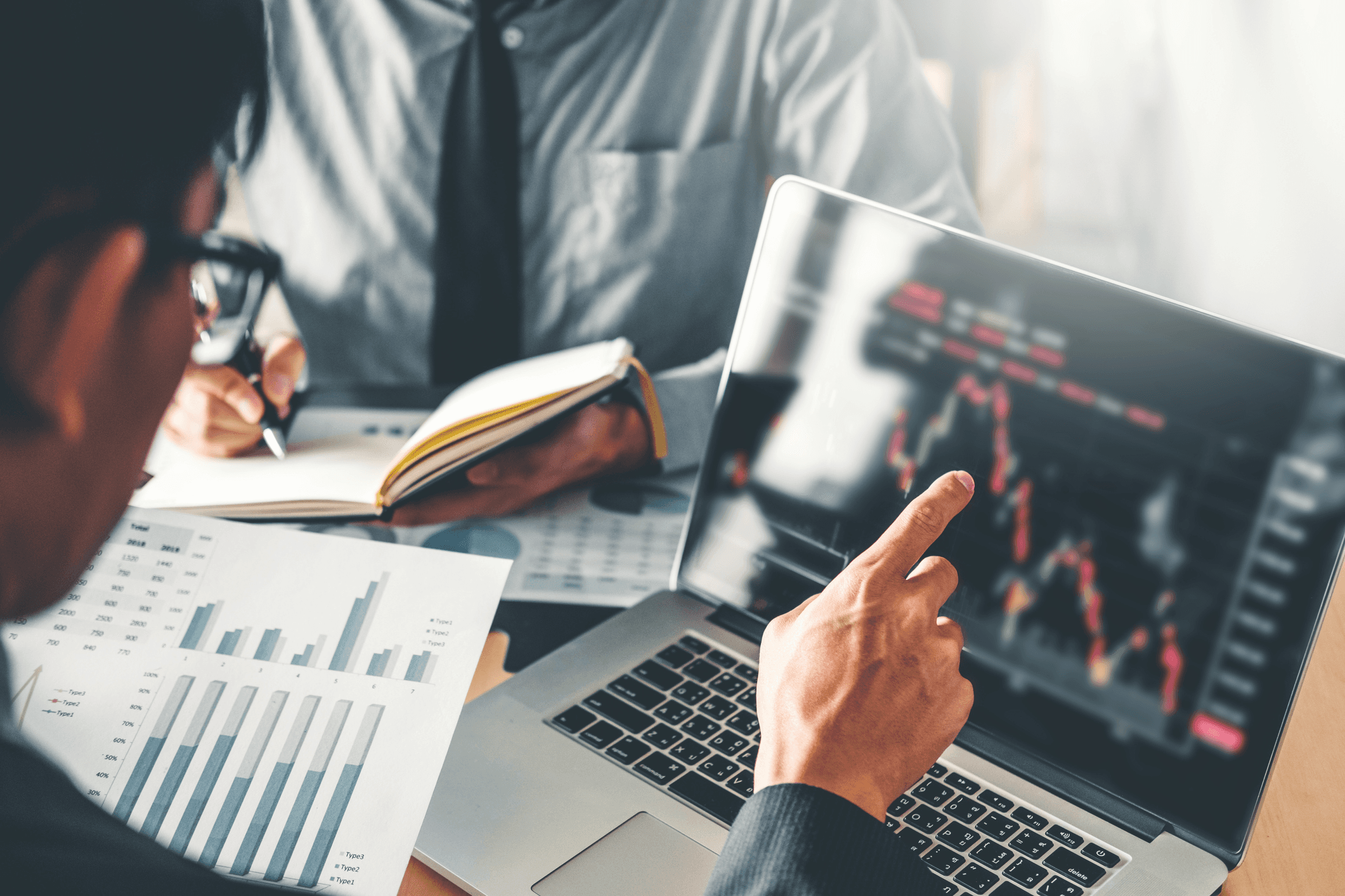 Two persons discussing market trading data - Futures Trading Basics