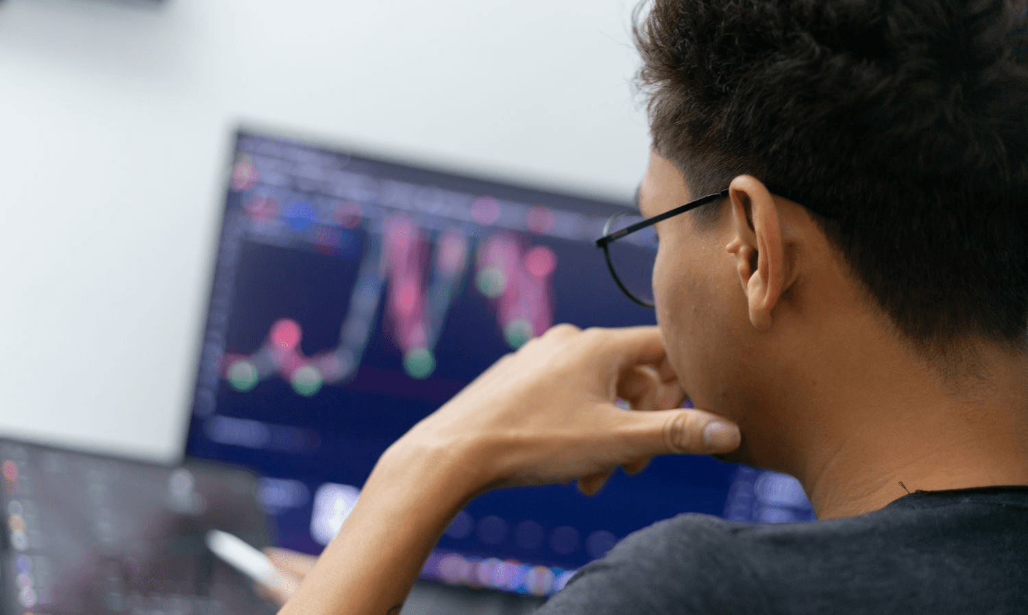 Man analyzes financial market trading chart - What Is Margin Compression