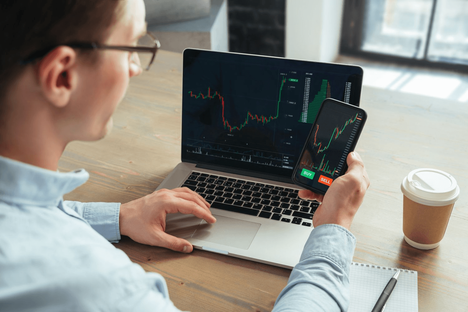 Man monitors trading charts on devices - How to Calculate Implicit Interest Rate