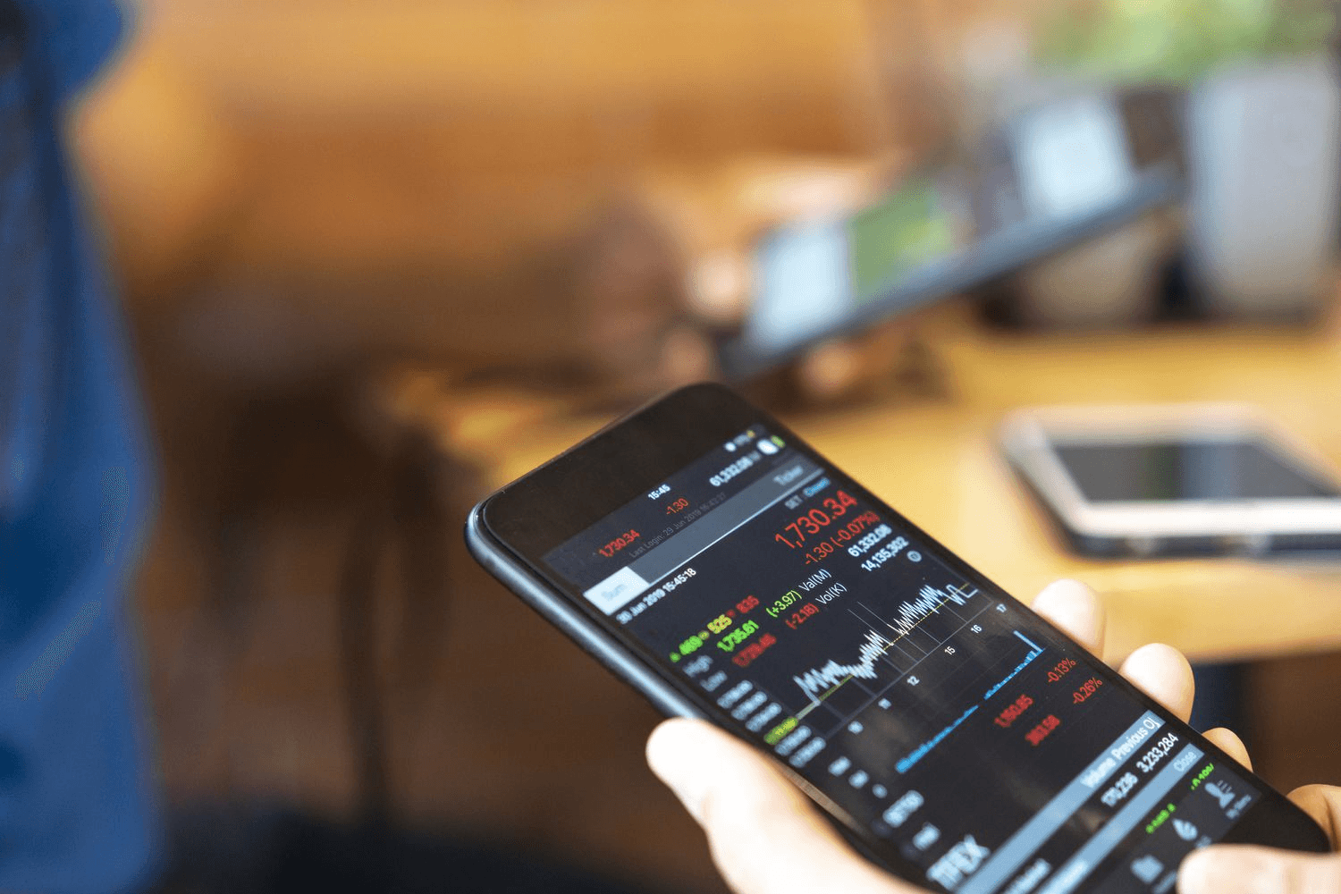 Person views financial charts on smartphone - How to Calculate Implicit Interest Rate