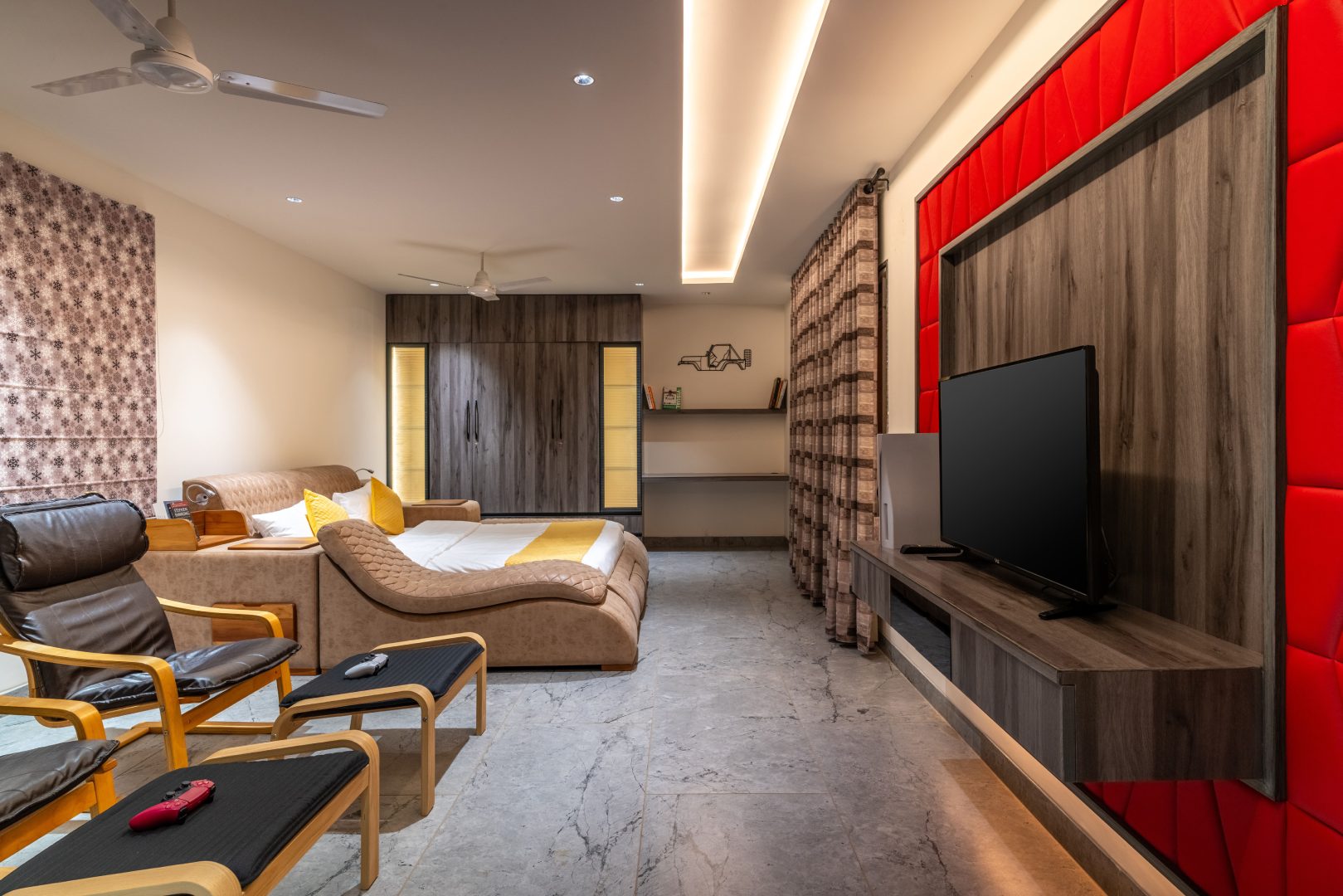 Spacious luxury bedroom at Sri Narayana Vanam farmhouse featuring a king-size bed, comfortable seating area, large flat-screen TV, premium wooden interiors, soft ambient lighting, and air-conditioned comfort, offering a peaceful stay at a private farm stay and vacation rental in Aziznagar, Moinabad, Hyderabad, located at Survey No. 129. Contact: 998-994-1555.