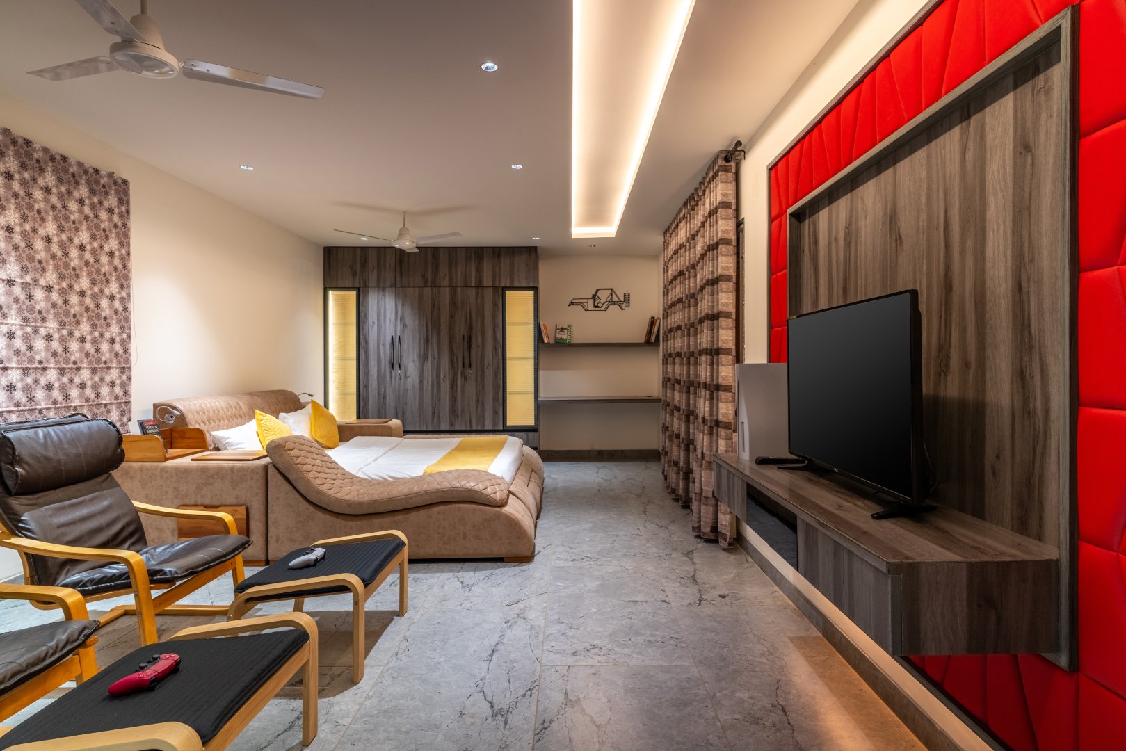 Spacious luxury bedroom at Sri Narayana Vanam farmhouse featuring a king-size bed, comfortable seating area, large flat-screen TV, premium wooden interiors, soft ambient lighting, and air-conditioned comfort, offering a peaceful stay at a private farm stay and vacation rental in Aziznagar, Moinabad, Hyderabad, located at Survey No. 129. Contact: 998-994-1555.