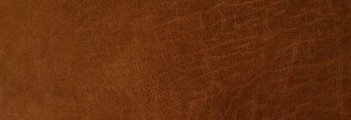 Texture de cuir marron avec des motifs naturels et des plis visibles.