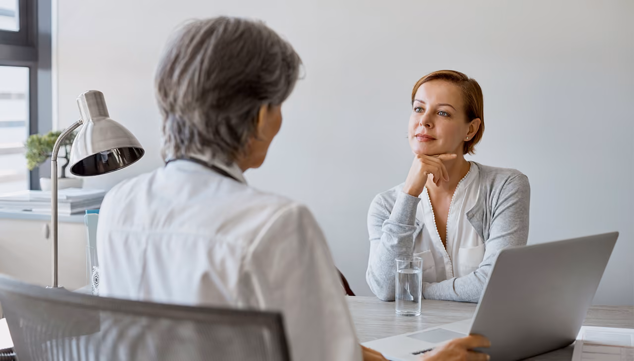 A patient speaks with a healthcare professional during an office consultation.