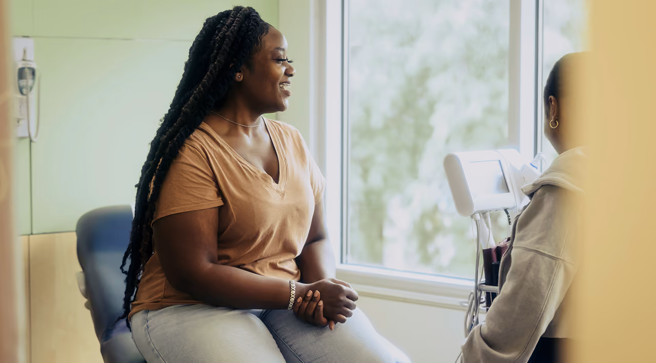 An older man discusses his health with a healthcare professional during an appointment.
