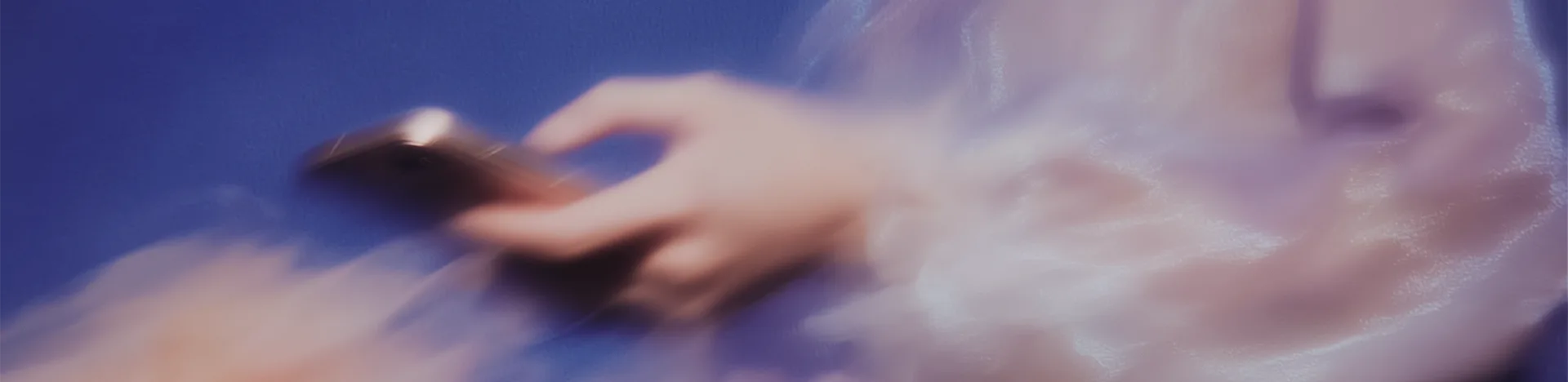 Woman in patterned suit floating while typing on a laptop, with digital code projected behind her on a pink background.