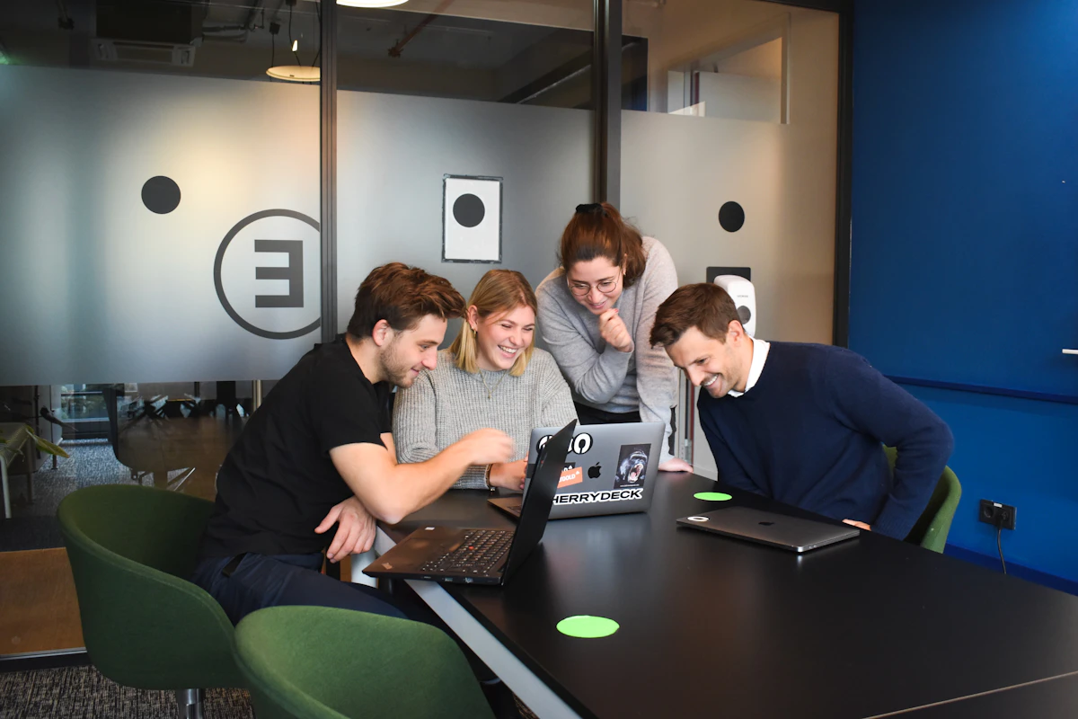 Technology specialists collaborating around a laptop