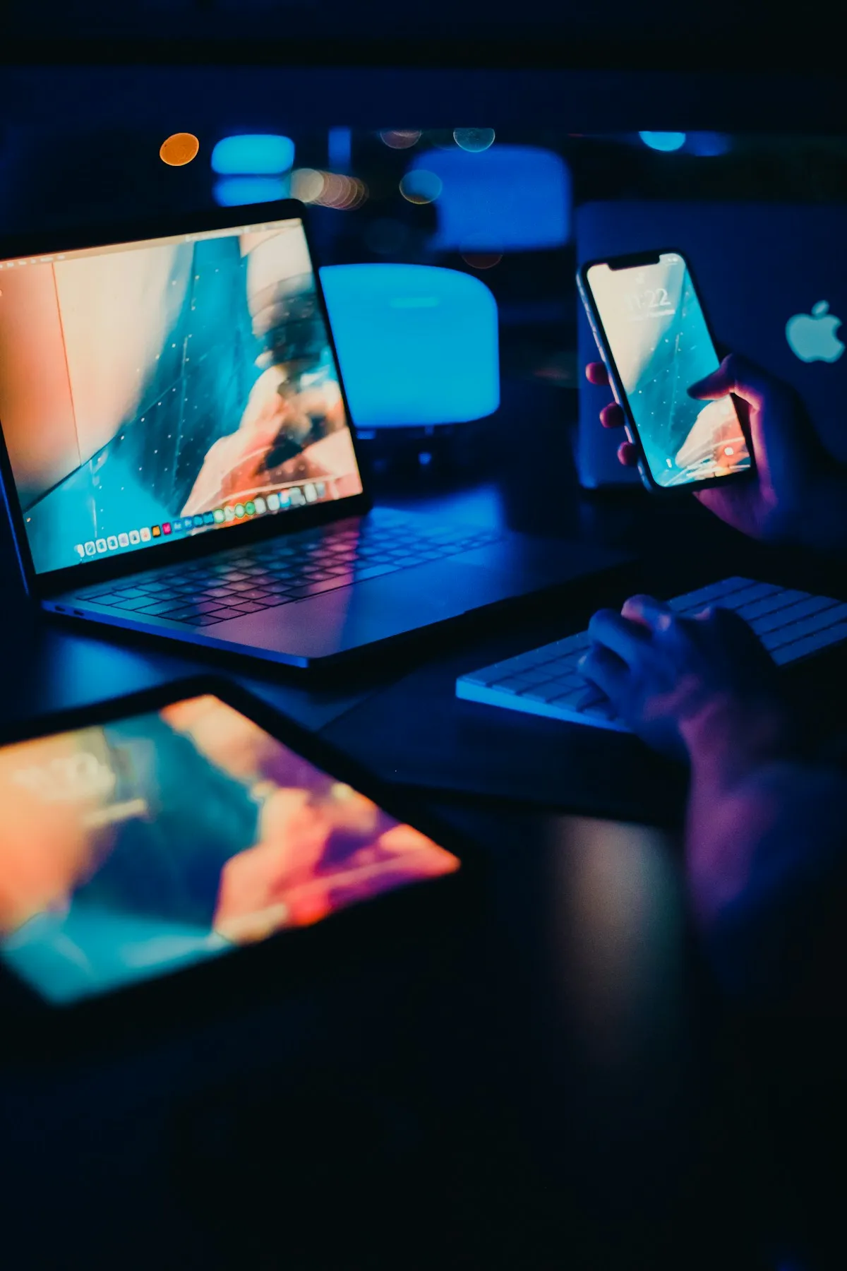 MacBook, iPhone and iPad being used together at a desk