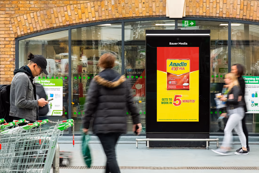 An Anadin Extra advert on a digital Asda Live screen outside of the Asda storefront