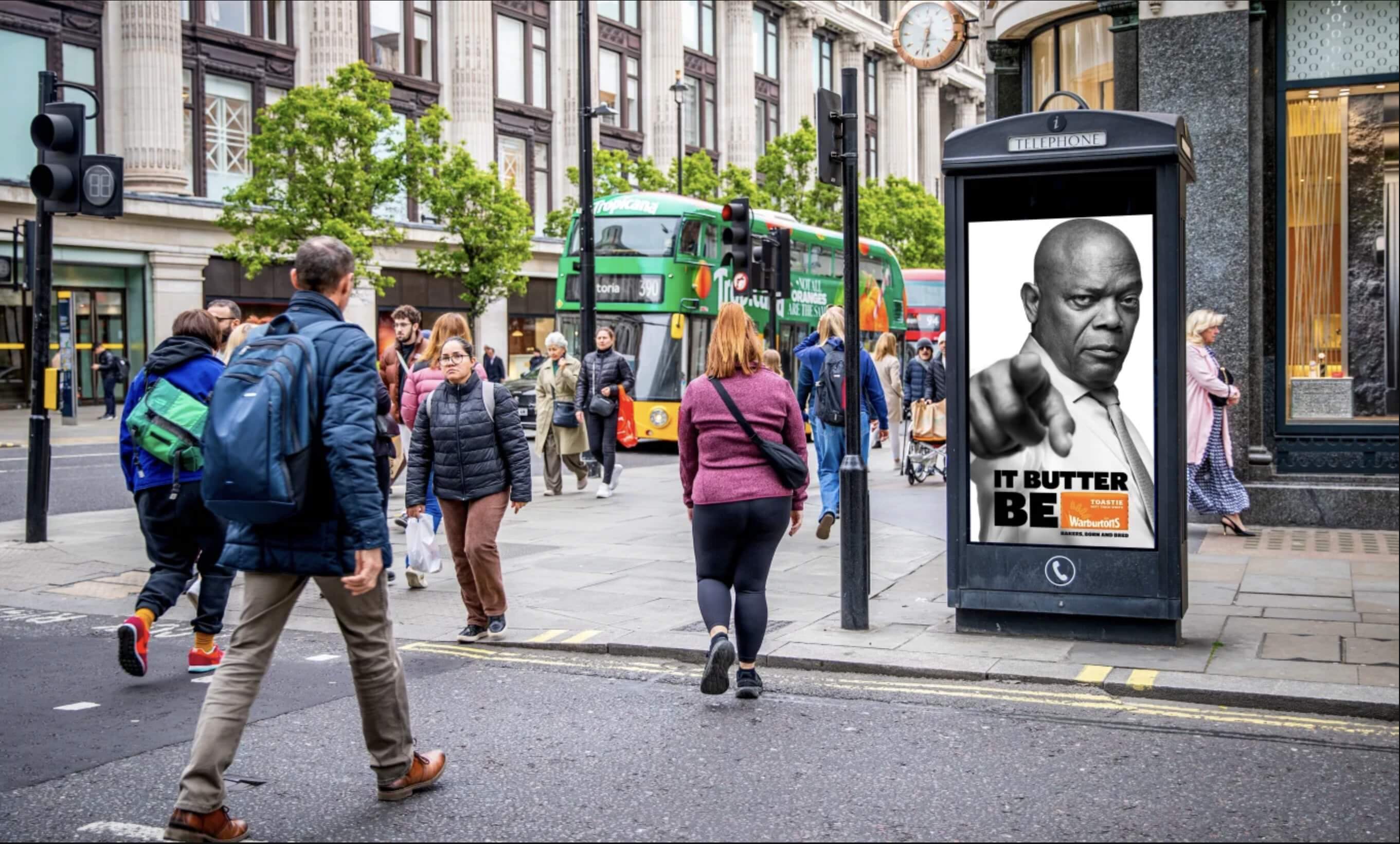 Bauer Media Outdoor digital advertising screen on high street displays a Warburtons ad featuring Samuel L. Jackson with the line “It Butter Be".