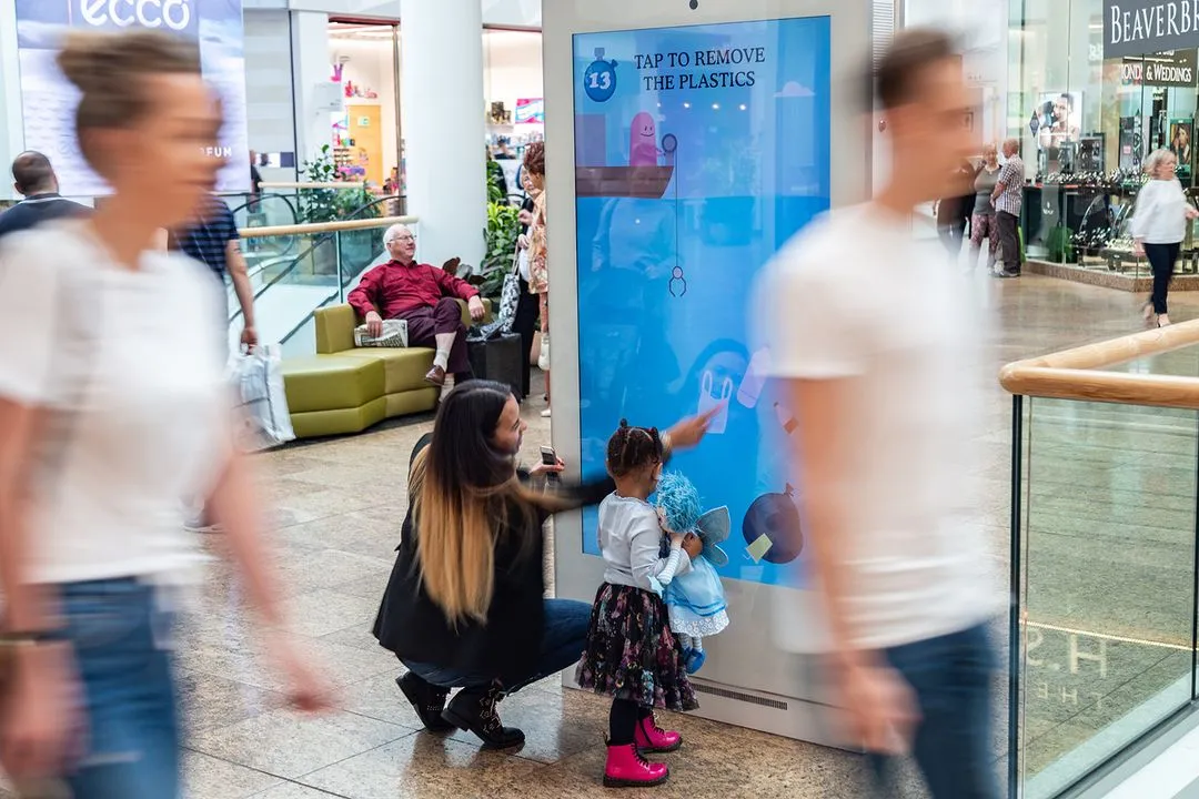 A family play on an interactive digital screen in a shopping mall