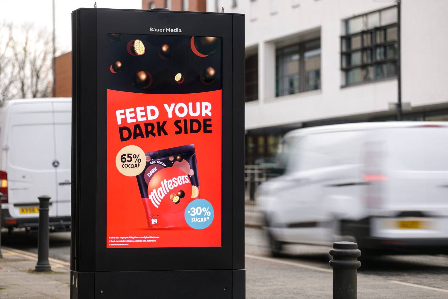 A Malteasers ad campaign advertising dark chocolate on a digital outdoor screen