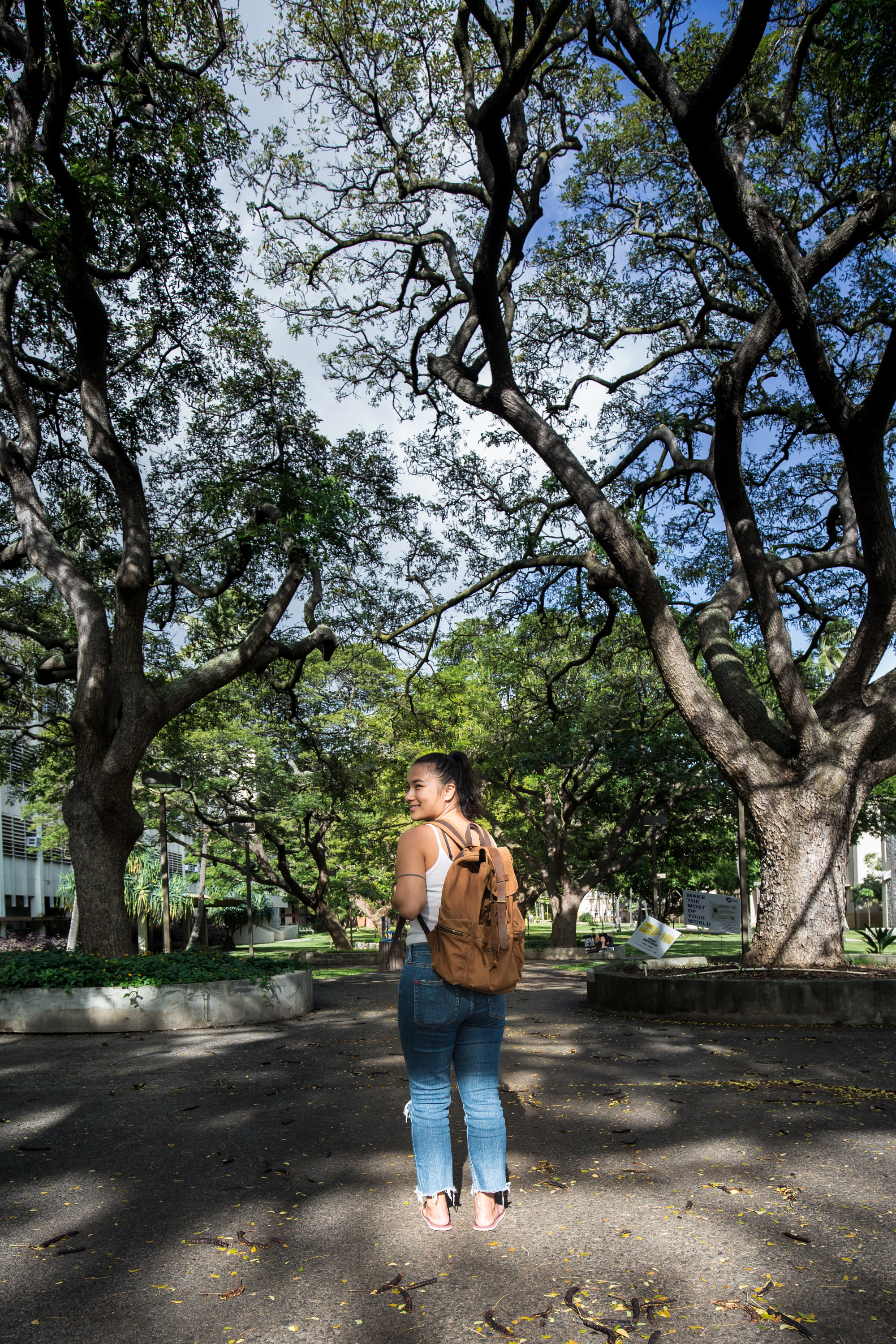 RISE Student posing by trees with backpack