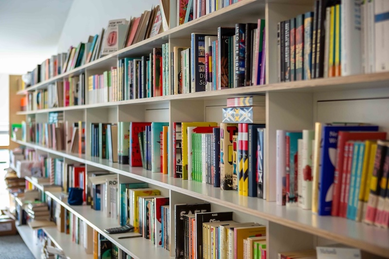 A shelf in Pan Macmillan's office displaying a large number of books. 
