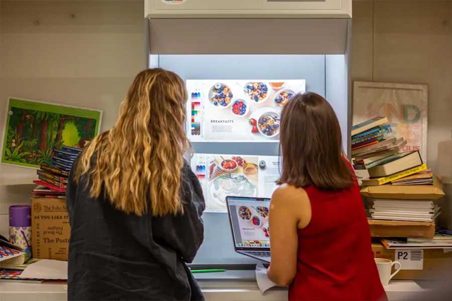 Two female Pan Macmillan employees working collaboratively on a layout for a book spread.