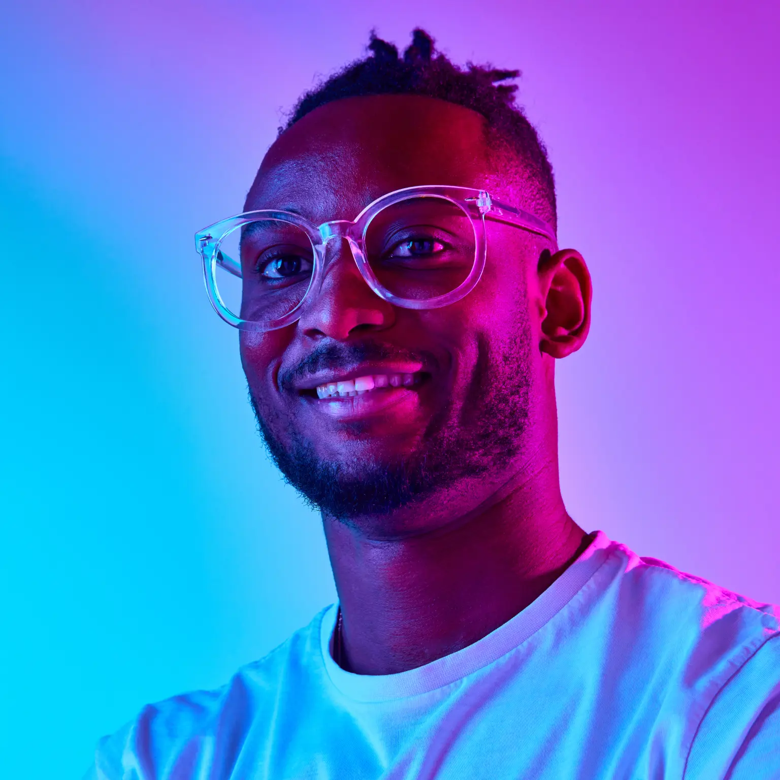 A man with glasses, smiling.