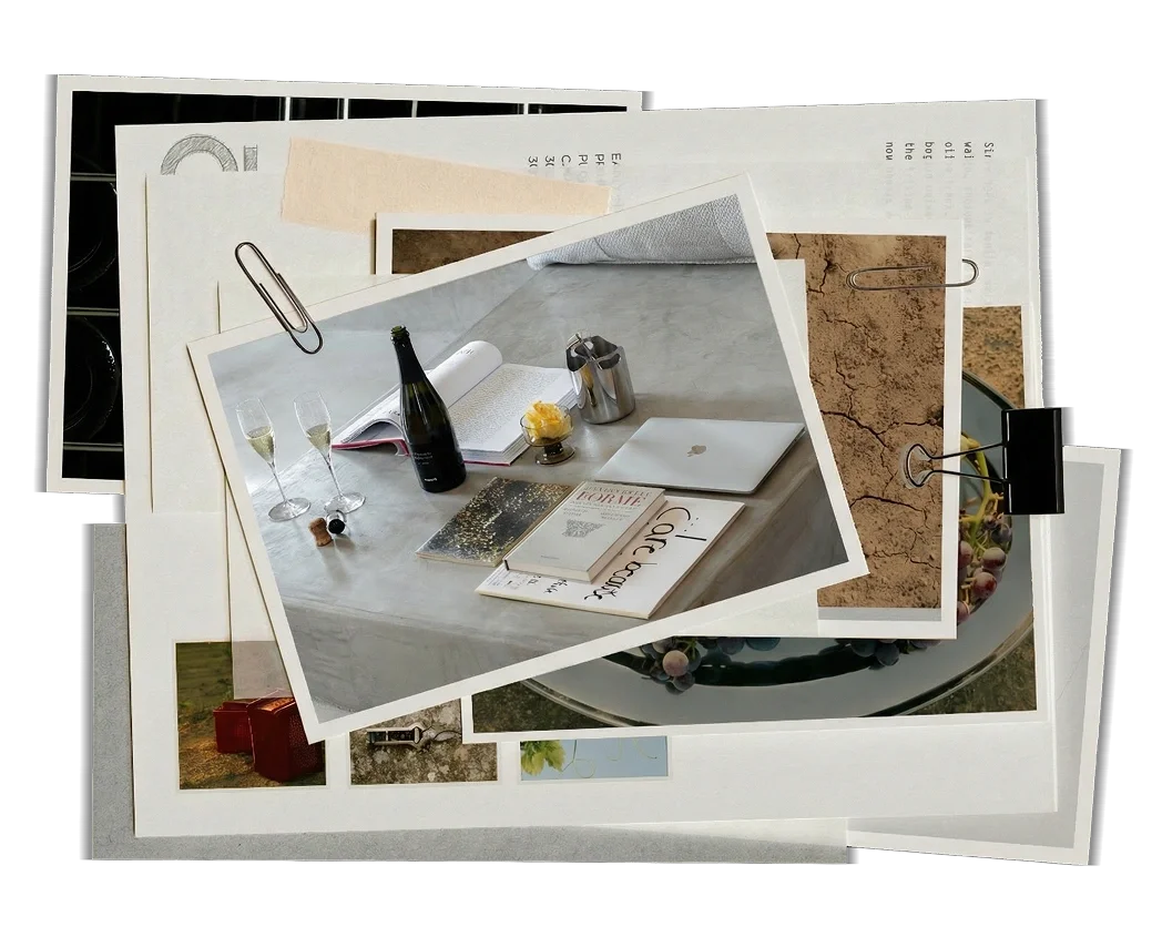 Scrapbook-style collage of overlapping photographs and papers, featuring an image of a table with a bottle of champagne, two filled glasses, open book, notebooks, and a closed laptop.  Frisino - Masseria Vallenza