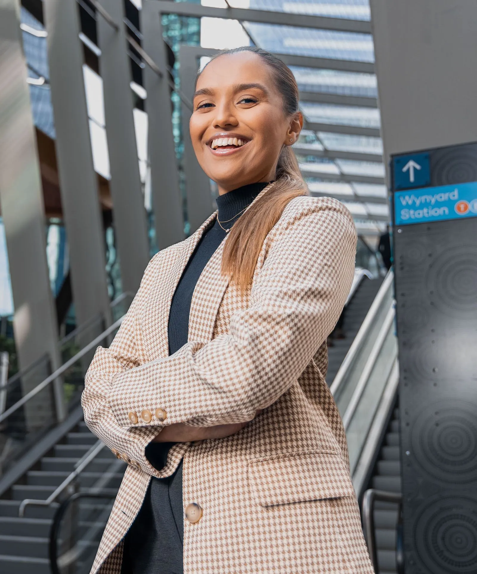 Confident Flight Centre staff standing with crossed arms and smiling at camera