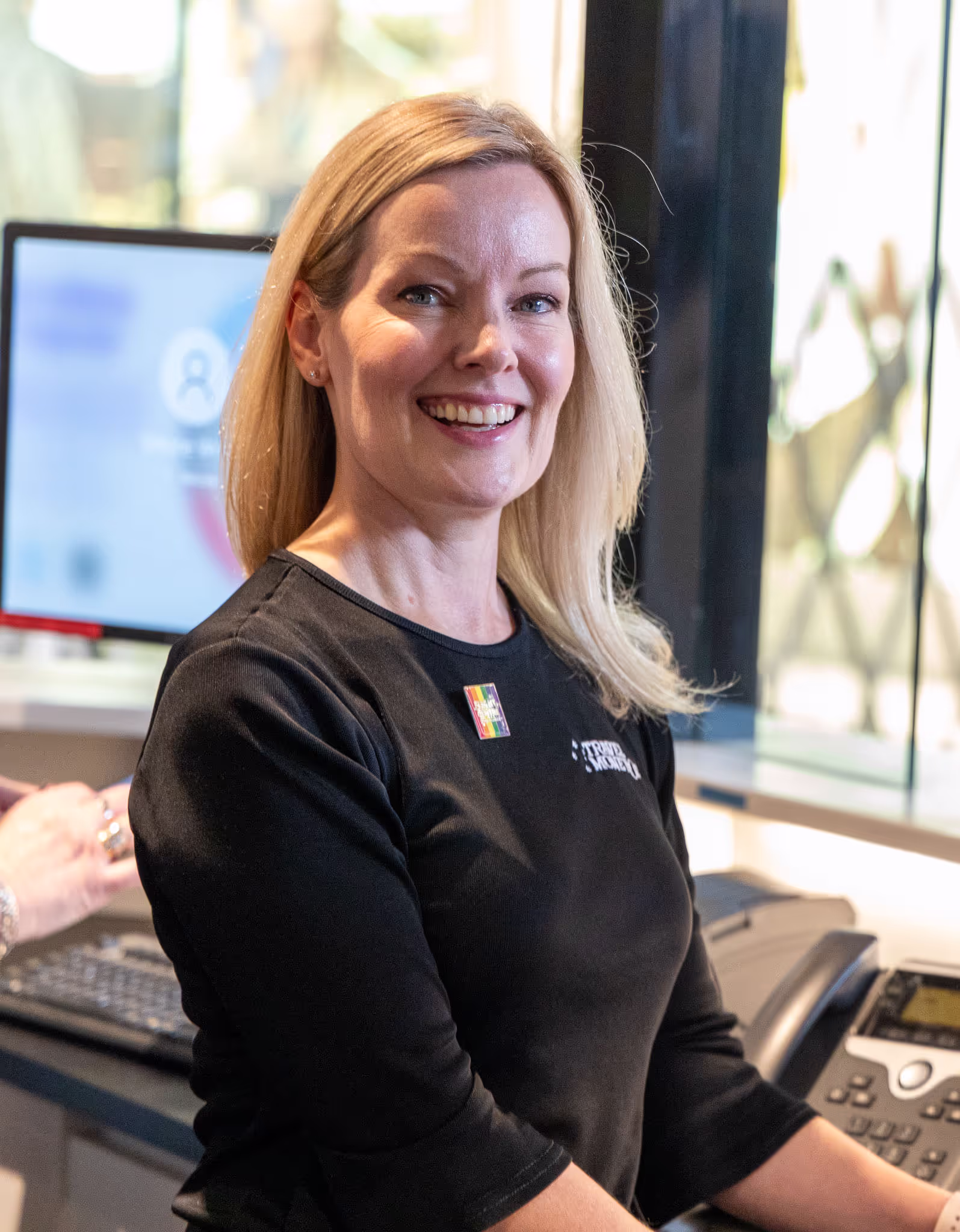Welcoming Flight Centre staff member in black shirt with a warm smile